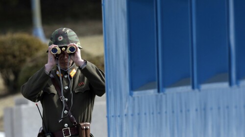 FILE - A North Korean soldier looks at the southern side through a pair of binoculars at the border village of the Panmunjom, in the Demilitarized Zone, DMZ, that separates the two Koreas since the Korean War, in Paju, north of Seoul, South Korea, Tuesday, March 19, 2013. A series of low-slung buildings and somber soldiers dot the landscape of the DMZ, the swath of land between North and South Korea where a soldier on a tour crossed into North Korea on Tuesday, July 18, 2023, under circumstances that remain unclear. (AP Photo/Lee Jin-man, File)