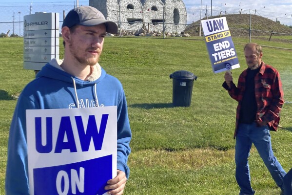 Logan Bohn, a member of the striking United Auto Workers, stands outside the Stellantis plant that makes Jeeps in Toledo, Ohio, on Friday, September 15, 2023. Bohn is a temporary worker at the plant. The UAW is seeking a contract that will end a big disparity in pay for temporary workers. (AP Photo/John Seewer)