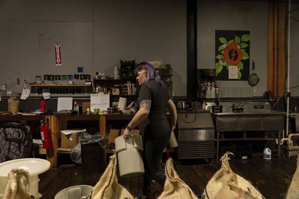 Renee Colon, co-owner of Fuego Coffee Roasters, works at her roasting facility Friday, March 21, 2025, in Rochester, N.Y. (Max Conway via AP)