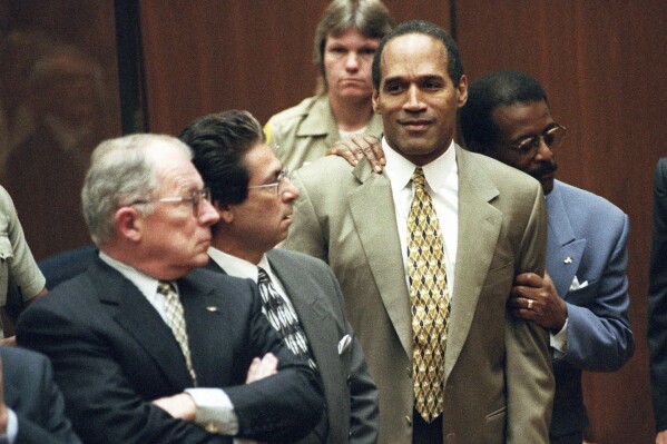 FILE - In this Oct. 3, 1995 file photo, attorney Johnnie Cochran Jr. holds O.J. Simpson as the not guilty verdict is read in a Los Angeles courtroom during his trial in Los Angeles. Defense attorneys F. Lee Bailey, left, Robert Kardashian look on. Simpson, the decorated football superstar and Hollywood actor who was acquitted of charges he killed his former wife and her friend but later found liable in a separate civil trial, has died. He was 76. (Myung J. Chun/Los Angeles Daily News via AP, Pool, File)