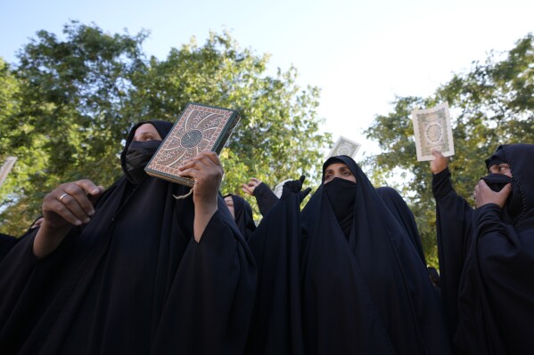 Iraqis raise copies of the Quran, Muslims' holy book, during a protest in Baghdad, Iraq, Saturday, July 22, 2023. Hundreds of protesters have attempted to storm Baghdad’s heavily fortified Green Zone, which houses foreign embassies and the seat of Iraq’s government, following reports of the burning of a Quran by a ultranationalist group in front of the Iraqi Embassy in Copenhagen. (AP Photo/Hadi Mizban)