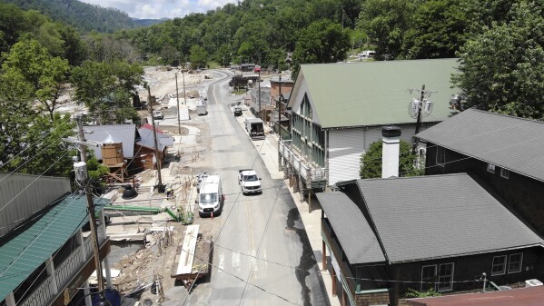 A truck drives down a nearly deserted Main Street in Chimney Rock Village, N.C., on Wednesday, May 14, 2025. (AP Photo/Allen G. Breed)