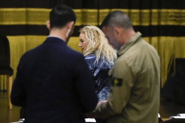 Judge Maria Francesca Mariano is escorted by plain clothes police as she arrives at the Apollo Theatre in Lecce, Italy, before the performance of her latest play "Your Honor, on the side of the guilty", Monday, May 20, 2024. Mariano is living under 24 hour police escort after receiving death threats. In July 2023 Mariano issued the arrest warrants for 22 members of the Lamendola Clan accused of mafia association, drug trafficking, attempted homicide, possession of illegal weapons. (AP Photo/Alessandra Tarantino)