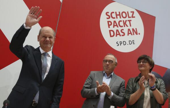 German Social Democratic Party, SPD, party leaders Saskia Esken, right, and Norbert Walter-Borjans, center, applaud  to the party's candidate for chancellery Olaf Scholz as he arrives at the meeting of the SPD Federal Executive Committee in Berlin, Germany, Monday, Sept. 27, 2021. Following Sunday's election leaders of the German parties were meeting Monday to digest a result that saw Merkel’s Union bloc slump to its worst-ever result in a national election and appeared to put the keys to power in the hands of two opposition parties. Both Social Democrat Olaf Scholz and Armin Laschet, the candidate of Merkel's party, laid a claim to leading the next government. (Wolfgang Kumm/dpa via AP)