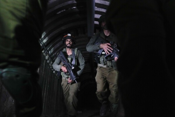 Israeli soldiers are seen in a tunnel that the military says Hamas militants used to attack the Erez crossing in the northern Gaza Strip, Friday, Dec. 15, 2023. The army is battling Palestinian militants across Gaza to retaliate for Hamas' Oct. 7 attack on Israel. (AP Photo/Ariel Schalit)