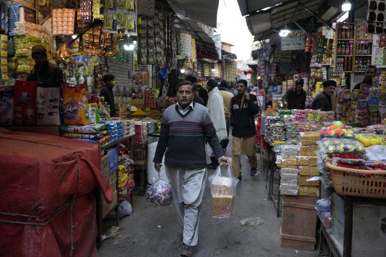 People visit a market to buy groceries and other stuff, in Rawalpindi, Pakistan, Tuesday, Feb. 6, 2024. More than 120 million voters in Pakistan get to elect a new parliament on Thursday. The elections are the twelfth in the country's 76-year history, which has been marred by economic crises, military takeovers and martial law, militancy, political upheavals and wars with India. (AP Photo/Anjum Naveed)