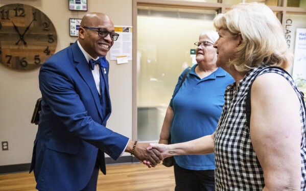 FILE - Dr. Claude Tiller Jr. shakes hands at the Aging & Disability Resource Center of Brown County on July 18, 2023, in Green Bay, Wis. The Green Bay school district on Wednesday, Feb. 21, 2024, released the recording of its first Black superintendent's appearance on an Atlanta radio show in which he made blunt comments about race relations, criticized the community and derided one of the district's principals. Tiller Jr. resigned on Saturday after a closed-door meeting with school board members.(Seeger Gray/The Green Bay Press-Gazette via AP, File)