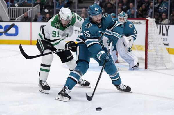 San Jose Sharks defenseman Erik Karlsson (65) works for the puck against Dallas Stars center Tyler Seguin (91) during the second period of an NHL hockey game Wednesday, Jan. 18, 2023, in San Jose, Calif. (AP Photo/Tony Avelar)