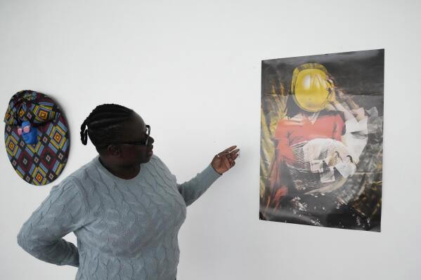 Fadzai Muchemwa, National Art Gallery curator, looks at Nothando Chiwanga's art piece, "Immortal", in Harare, Friday, April, 14, 2023. Chiwanga's "Immortal" is one of 21 works by female artists that have been on show at the southern African country's national gallery since International Women's Day on March 8. The exhibition is titled "We Should All Be Human" and is a homage to women's ambitions and their victories, Muchemwa said. (AP Photo/Tsvangirayi Mukwazhi)