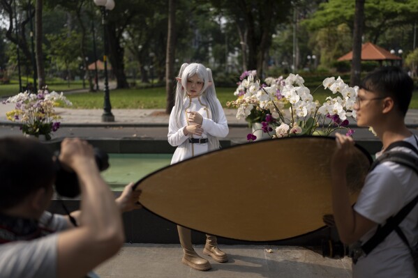 A woman dressed as a character poses for photos at a park in Ho Chi Minh City, Vietnam, Jan. 14, 2024. (AP Photo/Jae C. Hong)