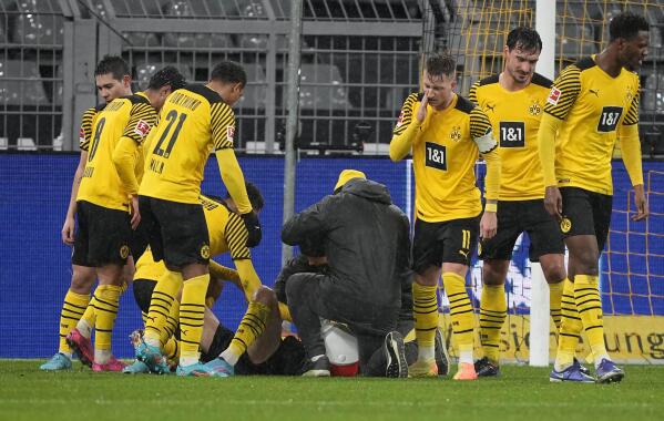 Dortmund's injured Giovanni Reyna gets treatment on the pitch during the German Bundesliga soccer match between Borussia Dortmund and Borussia Moenchengladbach in Dortmund, Germany, Sunday, Feb. 20, 2022. (AP Photo/Martin Meissner)