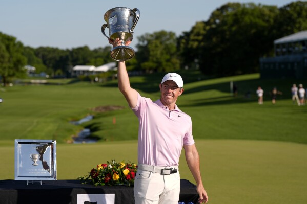 Rory McIlroy, of Northern Ireland, holds the trophy after winning the Wells Fargo Championship golf tournament at the Quail Hollow Club Sunday, May 12, 2024, in Charlotte, N.C. (Ǻ Photo/Chris Carlson)