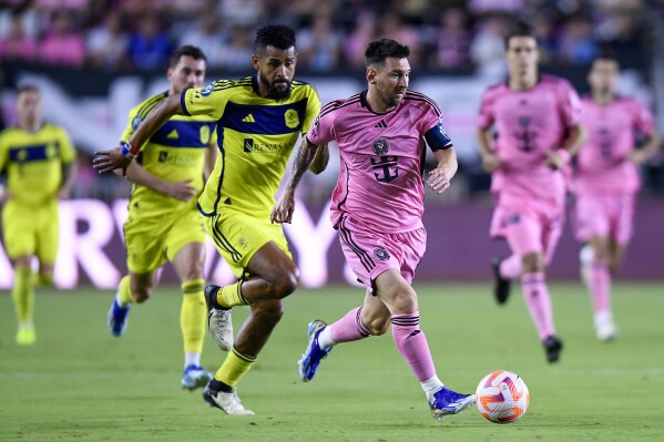 Inter Miami forward Lionel Messi races ahead of Nashville SC midfielder Anibal Godoy during the first half of a CONCACAF Champions Cup soccer match Wednesday, March 13, 2024, in Fort Lauderdale, Fla. (AP Photo/Michael Laughlin)
