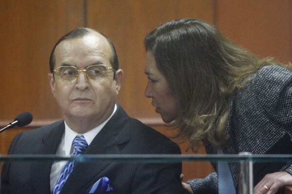 FILE - Vladimiro Montesinos, left, listens to his lawyer Estela Valdivia as he testifies at the trial of Peru's former President Alberto Fujimori in Lima, June 30, 2008. Montesinos pleaded guilty, Monday, Jan 29, 2024, to charges in the 1992 massacre of six farmers who were accused of being members of a rebel group, taken from their homes by soldiers and executed in the town of Pativilca. (AP Photo/Martin Mejia, File)