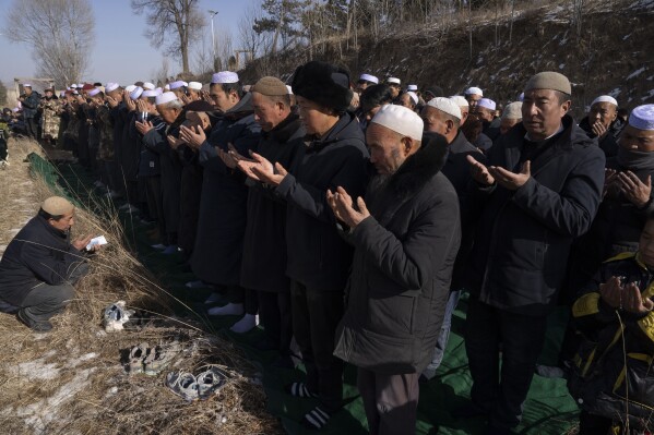 Residents pray during rituals to bury victims of an earthquake at a local cemetery in Yangwa village near Dahejia town in northwestern China's Gansu province, Wednesday, Dec. 20, 2023. (AP Photo/Ng Han Guan)
