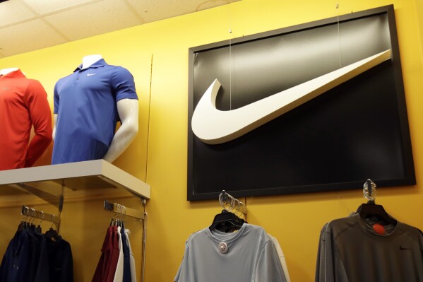 FILE - In this Nov. 29, 2019, file photo Nike clothes are displayed at a store in Colma, Calif. Nike is cutting 2% of its global workforce, or a little over 1,600 jobs, as the athletic wear giant aims to cut costs and reinvests its savings into what it sees as big growth areas like sport, health and wellness. (AP Photo/Jeff Chiu, File)