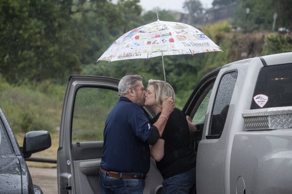 A couple share a kiss under an umbrella near the Mississippi River in Natchez, Miss. Friday, Oct. 9, 2020, as local residents prepare for the rains of Hurricane Delta. (Eric Shelton/The Clarion-Ledger via AP)