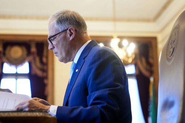 FILE - Washington Gov. Jay Inslee reads notes in his office before his State of the State address on the second day of the legislative session at the Washington state Capitol, Tuesday, Jan. 9, 2024, in Olympia, Wash. Inslee on Tuesday, Jan. 30, called for the state to develop best practices on how agencies should use generative artificial intelligence as it continues to incorporate the technology into government operations. (APPhoto/Lindsey Wasson, File)