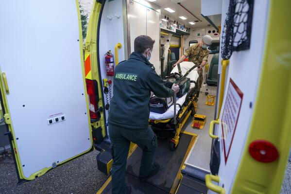 Military co-responders Lt. Corydon Morrell, background and Major James Allen board an ambulance,  at the NHS South Central Ambulance Service Bracknell Ambulance Station in Bracknell, England, Wednesday, Jan. 12, 2022, where the military personnel are being used to supplement the NHS during staffing shortages resulting from increased isolation due to the Omicron COVID-19 variant. (Steve Parsons PA via AP)