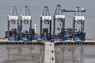 Quay cranes load containers on a ship at a container terminal in Shanghai, China on Sunday, April 27, 2025. (Chinatopix via AP)