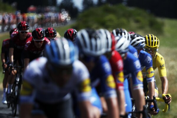 The pack with France's Julian Alaphilippe wearing the overall leader's yellow jersey, right, rides during the ninth stage of the Tour de France cycling race over 170.5 kilometers (105.94 miles) with start in Saint Etienne and finish in Brioude, France, Sunday, July 14, 2019. (AP Photo/Thibault Camus)