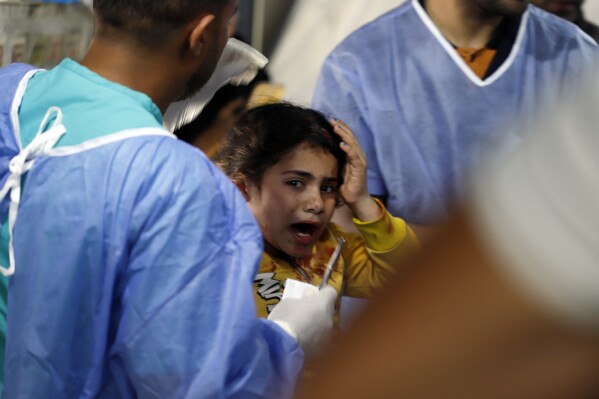 Palestinian medics treat a girl wounded in the Israeli bombardment of the Gaza Strip at the Kuwaiti Hospital in Rafah refugee camp, southern Gaza, Tuesday, May 7, 2024. (AP Photo/Ramez Habboub)