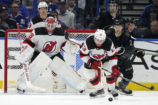 New Jersey Devils center Nico Hischier (13) intercepts a pass intended for Tampa Bay Lightning center Brayden Point (21) in front of goaltender Mackenzie Blackwood (29) during the first period of an NHL hockey game Saturday, Nov. 20, 2021, in Tampa, Fla. (AP Photo/Chris O'Meara)