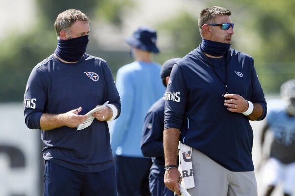 FILE - In this Aug. 24, 2020, file photo, Tennessee Titans outside linebackers coach Shane Bowen, left, and head coach Mike Vrabel watch players during NFL football training camp in Nashville, Tenn. The NFL and the NFL Players Association found instances when the Titans failed to wear masks at all times and were “insufficiently clear” to players about not meeting or working out once the facility closed in a review given to the team Monday, Oct. 19, 2020, a person familiar with the investigation told The Associated Press. But the person familiar with the review says there was no discussion of any discipline for an individual including general manager Jon Robinson, coach Mike Vrabel or any players, and there was no discussion of punishment, including forfeitures or draft picks.  (George Walker IV/The Tennessean via AP, Pool, File)