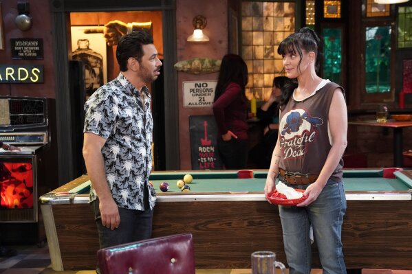 This image released by CBS shows Al Madrigal, left, and Pauley Perrette in a scene from the comedy "Broke," debuting on Thursday at 9:30 p.m. EDT. (Greg Gayne/CBS via AP)