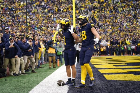 Michigan wide receiver Roman Wilson (1) celebrates his touchdown reception with Colston Loveland (18) in the first half of an NCAA college football game against Indiana in Ann Arbor, Mich., Saturday, Oct. 14, 2023. (AP Photo/Paul Sancya)
