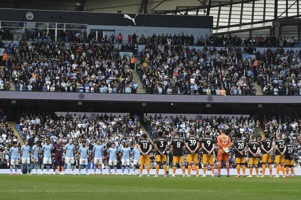Players of Manchester City, left, and Leeds United stand during the national anthem prior to the English Premier League soccer match at Etihad stadium in Manchester, England, Saturday, May 6, 2023. (AP Photo/Rui Vieira)