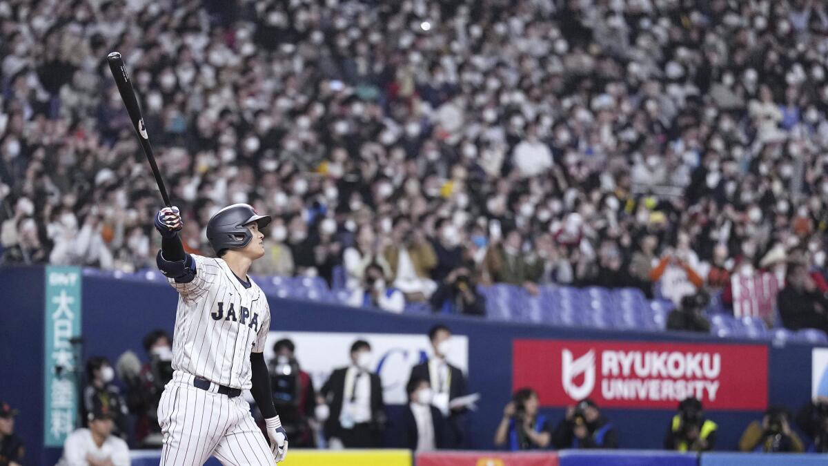 Shohei Ohtani of Japan's national baseball team smiles after hitting a  three-run home run in the third inning against the Hanshin Tigers in a  World Baseball Classic warm-up game on March 6