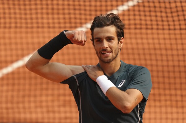 Italy's Lorenzo Musetti celebrates as he won the quarterfinal match of the French Tennis Open against Frances Tiafoe of the U.S. at the Roland-Garros stadium in Paris, Tuesday, June 3, 2025. (AP Photo/Aurelien Morissard)