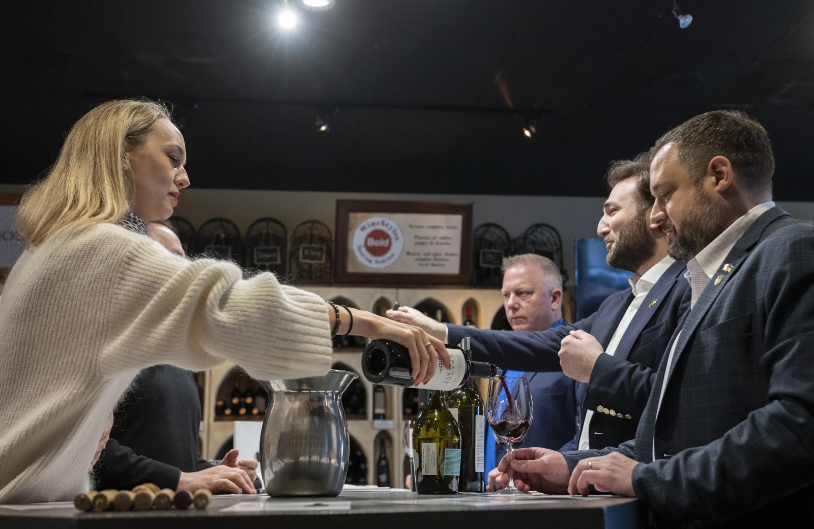 Inside WineStyles wine store, Valentyna pours wine for the wine tasting.