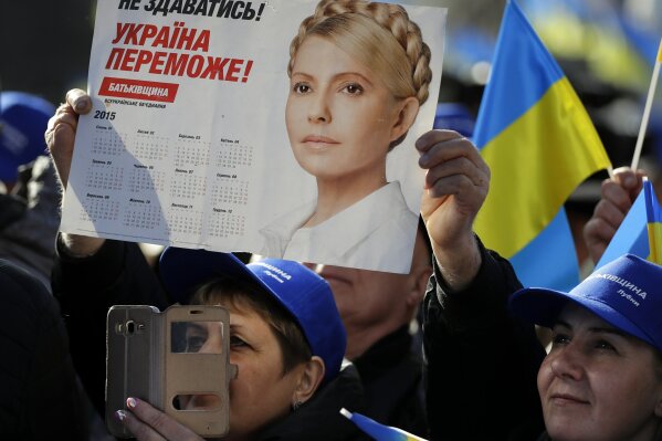 
              Supporters greet Former Ukrainian Prime Minister Yulia Tymoshenko, candidate for the 2019 presidential elections, during a rally in Kiev, Ukraine, Friday, March 29, 2019. Tymoshenko is running in the president election scheduled for March 31. The placard reading "To not give up! Ukraine will win!" (AP Photo/Sergei Grits)
            