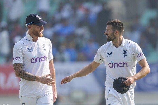 England's captain Ben Stokes, left talks with Mark Wood on the first day of the third cricket test match between India and England in Rajkot, India, Thursday, Feb. 15, 2024. (APPhoto/Ajit Solanki)