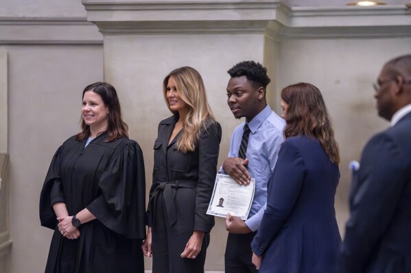 From left, Judge Elizabeth Gunn, and former first lady Melania Trump welcome newly-sworn American citizens as the National Archives holds a naturalization ceremony with 25 people from 25 nations, in Washington, Friday, Dec. 15, 2023. A naturalized citizen herself, Melania Trump, wife of former President Donald Trump, was originally from Slovenia. The event is part of the Archives' annual celebration of Bill of Rights Day. (AP Photo/J. Scott Applewhite)