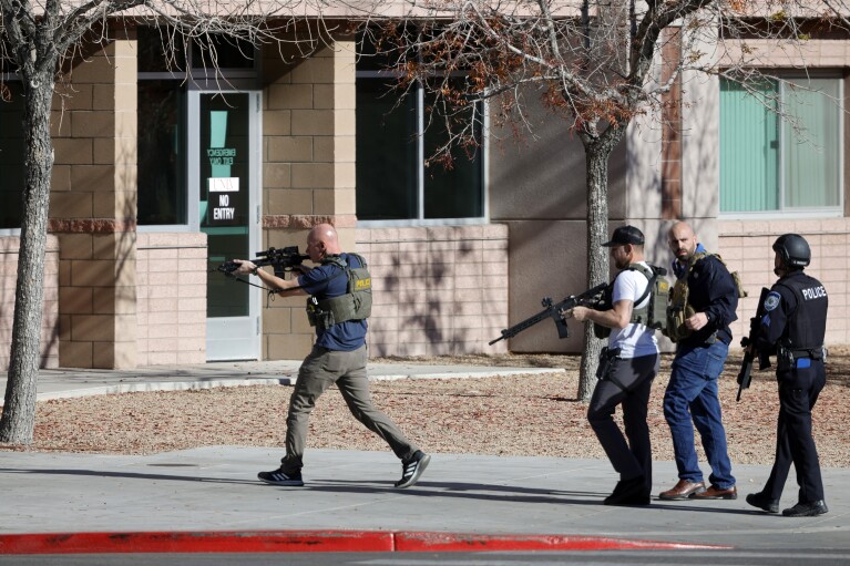Law enforcement officers head into the University of Nevada, Las Vegas, campus after reports of an active shooter, Wednesday, Dec. 6, 2023, in Las Vegas. (Steve Marcus/Las Vegas Sun via AP)