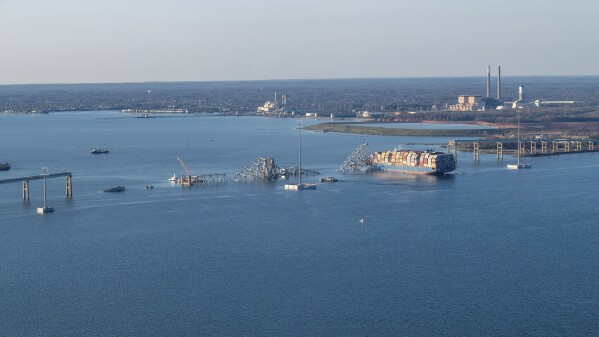 In this photo provided by the U.S. Coast Guard, the M/V Dali is seen with the collapsed Francis Scott Key Bridge, Saturday, March 30, 2024, in Baltimore.  Unified Command's priorities for the major bridge response are to ensure the safety of the public and first responders, hold missing persons accountable, safely restore transportation and trade infrastructure, protect the environment and support the investigation.  (Petty Officer 3rd Class Kimberly Reeves/U.S. Coast Guard via AP)