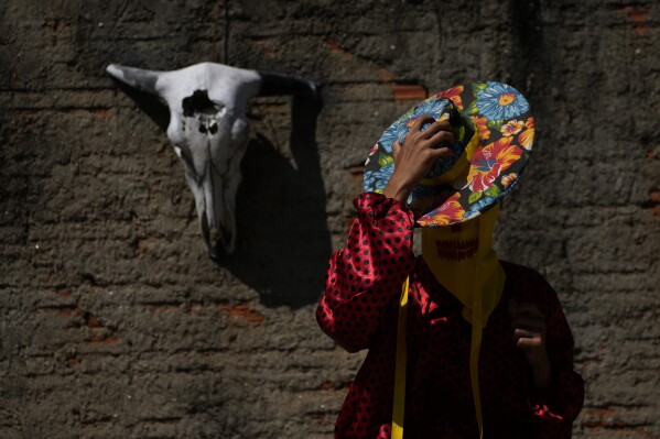 Un juerguista usa sombrero y disfraz durante las Cavalhadas, o Fiesta del Espíritu Santo, en Pirenópolis, estado de Goiás, Brasil, el domingo 8 de junio de 2025. (Foto AP/Eraldo Peres)