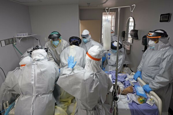 FILE - In this July 6, 2020, file photo, Dr. Joseph Varon, right, leads a team as they try to save the life of a patient unsuccessfully inside the Coronavirus Unit at United Memorial Medical Center, Monday, July 6, 2020, in Houston. The U.S. death toll from the coronavirus topped 200,000 Tuesday, Sept. 22, a figure unimaginable eight months ago when the scourge first reached the world’s richest nation with its sparkling laboratories, top-flight scientists and towering stockpiles of medicines and emergency supplies. (AP Photo/David J. Phillip, File)