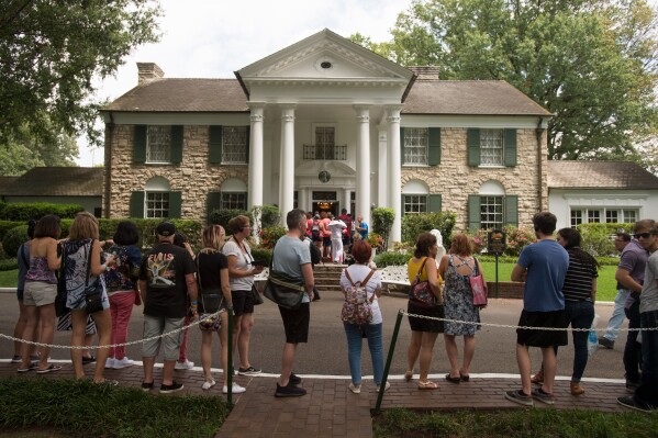 FILE - Fans wait in line outside Graceland, Elvis Presley's Memphis home, in Memphis, Tenn., Aug. 15, 2017. A mysterious company has caused a stir for trying to auction Elvis Presley's Graceland in a foreclosure sale this week. A judge has blocked the sale after Presley's granddaughter filed a lawsuit alleging fraud. (AP Photo/Brandon Dill, File)