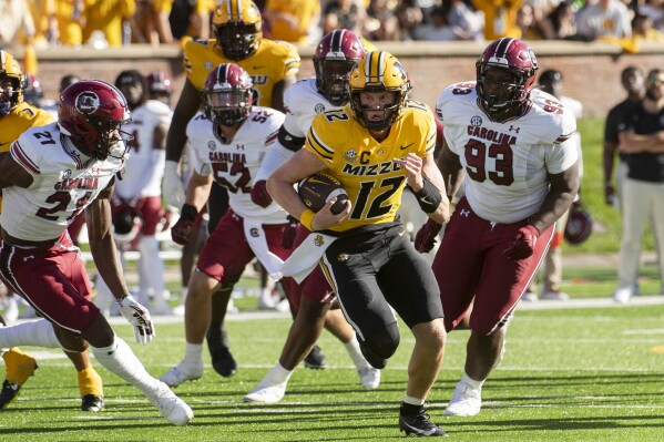 Missouri quarterback Brady Cook (12) runs past the South Carolina defense to score a touchdown during the second quarter of an NCAA college football game Saturday, Oct. 21, 2023, in Columbia, Mo. (AP Photo/L.G. Patterson)