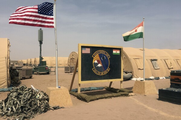 ARCHIVO - Banderas de Níger y Estados Unidos ondean en el campamento para miembros de la fuerza aérea y otro personal que ayuda en la construcción de la Base Aérea 201 de Níger, el 16 de abril de 2018, en Agadez, Níger. (AP Foto/Carley Petesch, Archivo)