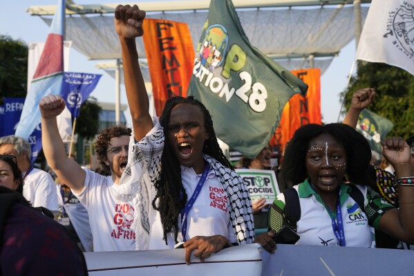 Activists, including Eric Njuguna, of Kenya, center, demonstrate for climate justice and a ceasefire in the Israel-Hamas war at the COP28 U.N. Climate Summit, Saturday, Dec. 9, 2023, in Dubai, United Arab Emirates. (AP Photo/Rafiq Maqbool)