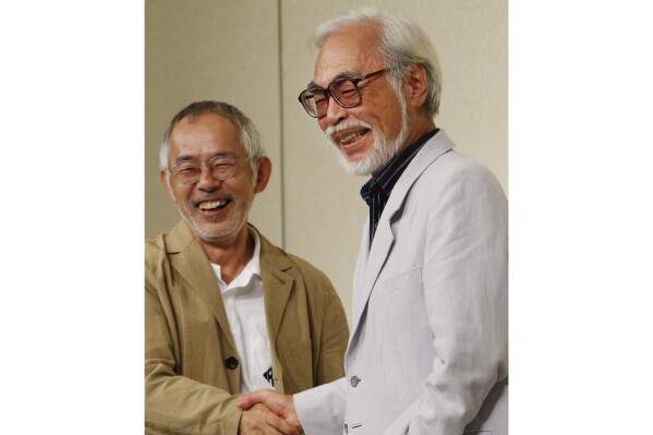 FILE - Hayao Miyazaki, right, one of animation's most admired and successful directors, shares a laugh with Toshio Suzuki, chairman and producer of Studio Ghibli Inc., as they shake hands during a news conference on his retirement in Tokyo on Sept. 6, 2013. Ghibli, the Japanese studio that just won its second Oscar for feature animation for "The Boy and The Heron," announced early Monday, March 11, 2024, in Japan, hasn't said yet what it plans next. But founder Hayao Miyazaki, who at 83 was the oldest director ever nominated in that category, won't rule out making another film, even if his next project is a short instead of a full-length feature. (AP Photo/Koji Sasahara, File)