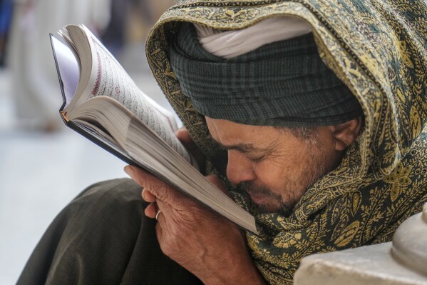 FILE - A Muslim reads the Islamic holy book "Quran", during the Muslims holy fasting month of Ramadan, at Al-Azhar mosque, the Sunni Muslim world's premier Islamic institution, in Cairo, Egypt, Friday, March 31, 2023. In the Middle East and North Africa, where religion is often ingrained in daily life's very fabric, rejecting faith can come with social or other repercussions, so many of the "nones," a group that includes agnostics, atheists and "nothing in particular" conceal that part of themselves, as blasphemy laws and policies are widespread in the region. (AP Photo/Amr Nabil, File)