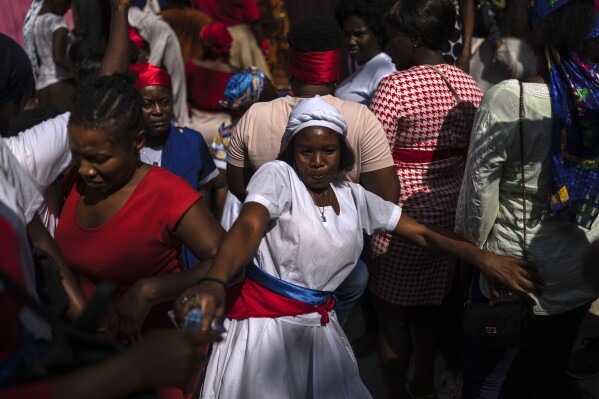 FILE - A Vodouist clad in white invokes a gede spirit during the Saint George celebration, in Port-au-Prince, Haiti, April 24, 2024. Shunned publicly by politicians and intellectuals for centuries, Vodou is transforming into a more powerful and accepted religion across Haiti, where its believers were once persecuted. (AP Photo/Ramon Espinosa, File)