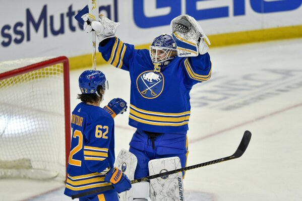 Buffalo Sabres goalie Linus Ullmark, right, reacts to defenseman Brandon Montour (62) scoring a short-handed, empty net goal against the Philadelphia Flyers during the third period of an NHL hockey game in Buffalo, N.Y., Wednesday, March. 31, 2021. Montour scored two short-handed goals in 37 seconds as Buffalo beat Philadelphia 6-1 to break an 18-game winless streak. (AP Photo/Adrian Kraus)