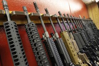 FILE - A row of rifles for sale is on display at a gun shop in Aurora, Colo., on July 20, 2012. The mass shooting in Buffalo, N.Y., has prompted questions about the effectiveness of “red flag laws” passed in 19 states and the District of Columbia. (AP Photo/Alex Brandon, File)